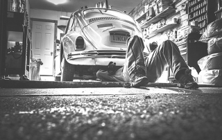 Un homme bricole sous sa voiture